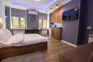 ein Schlafzimmer mit einem Bett und einem TV an der Wand in der Unterkunft Vip Apartment near Arena City in Kiew
