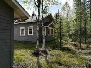 une maison avec un arbre en face dans l'établissement Räkkipirtti, à Luosto