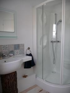 ein weißes Bad mit einem Waschbecken und einer Dusche in der Unterkunft B&B Chambre d'hôtes et Glamping, Bretagne mer et campagne Brittany sea and countryside in Pleumeur-Gautier