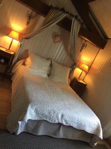 a bedroom with a bed with white sheets and pillows at La Roseraie in Trizay