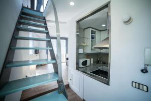 una escalera con pisadas azules en una pequeña cocina en Apartments Madrid Plaza Mayor-Tintoreros, en Madrid