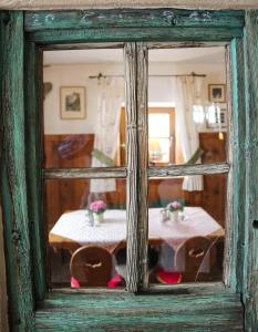 reflet d'une table dans une fenêtre en verre dans l'établissement Hotel Garni Kirchenwirt, à Sankt Leonhard im Pitztal