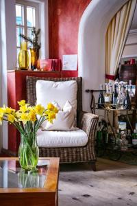 uma sala de estar com um vaso de flores amarelas sobre uma mesa em Hotel Garni Kirchenwirt em Sankt Leonhard im Pitztal