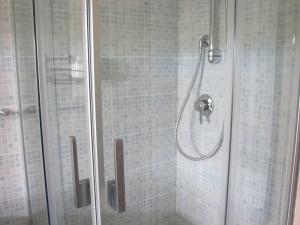 a shower with a glass door in a bathroom at New Casa Arcobaleno apartments-Room holiday home in Diano dʼAlba