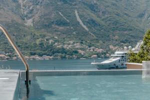 a swimming pool with a cruise ship in the water at Boutique Hotel Casa del Mare - Vizura in Kotor