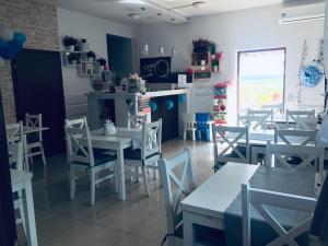 a dining room with white tables and chairs at Noclegi Lidzbark -Stacja Paliw k Lidzbarka in Lidzbark
