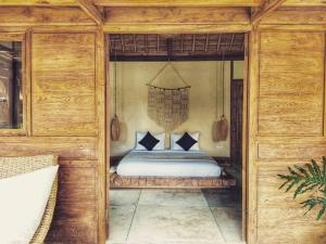 una camera da letto con letto in una camera in legno di Green Escape Eco Resort a Uluwatu
