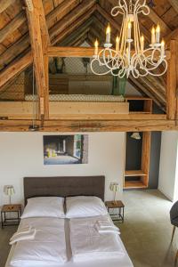 sypialnia z dużym łóżkiem i żyrandolem w obiekcie Ferienhaus am Rheinsteig / Nähe Hindenburghöhe / Loreley w mieście Lykershausen