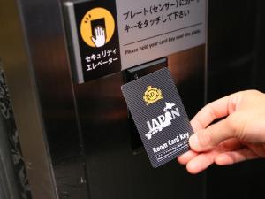 a hand holding a card in front of a machine at APA Hotel Shibuya Dogenzakaue in Tokyo