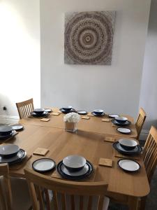 a wooden table with black and white plates on it at Blackpool Abode - Palatine House in Blackpool