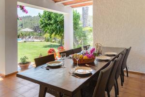 een eettafel met stoelen en een groot raam bij Villa Benirrás in Sant Miquel de Balansat