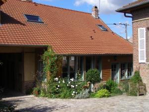 a brick house with an orange tile roof at Grange de la Herde in Camon