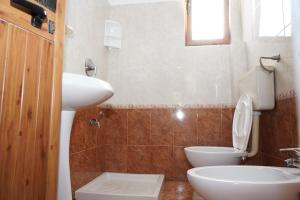 ein Badezimmer mit einem weißen WC und einem Waschbecken in der Unterkunft Vila Gridi- Apartamente me Qera in Spille