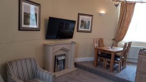 a living room with a table and a fireplace at Carnegie Library: Austen Apartment 2 bedroom in Mexborough