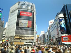 a crowd of people crossing a busy city street at APA Hotel Shibuya Dogenzakaue in Tokyo