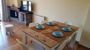 comedor con mesa con sillas y chimenea en Family Duplex Esterri, en Esterri d'Àneu