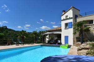 a villa with a swimming pool and a house at les palmiers des causses in Saint-Rome-de-Tarn