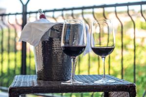 two glasses of wine sitting on a table with a basket at Mercury Rooms in Cagliari +25 photos