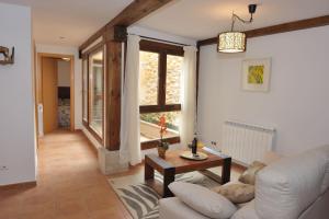 a living room with a white couch and a table at El Balcon De La Catedral in El Burgo de Osma