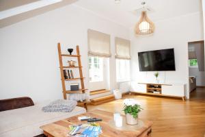 ein Wohnzimmer mit einem Couchtisch und einem Flachbild-TV in der Unterkunft Lossi 32 Penthouse in Tartu