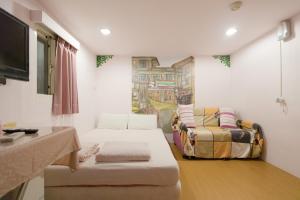 a living room with two beds and a couch at Jiufen Ligin B&B in Jiufen