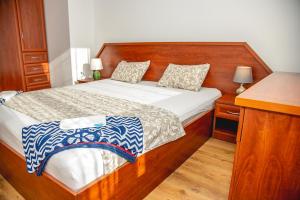 Schlafzimmer mit einem Bett mit einem Kopfteil aus Holz in der Unterkunft Nessebar's NEW Town / TOP Centre / 2-BDR Apartment in Nessebar