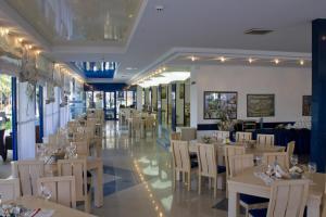 een eetkamer met tafels en stoelen in een restaurant bij Palace Hotel - Half Board in Sunny Beach