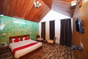 1 dormitorio con 1 cama y TV en una habitación en Tathastu Resort en Mukteswar