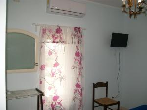 a room with a window with a curtain and a chair at Affittacamere il girasole in Recanati