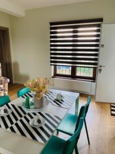 a dining room table with chairs and a window at Brickyard Apartments Cluj in Cluj-Napoca