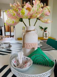 a vase with flowers in it sitting on a table at Brickyard Apartments Cluj in Cluj-Napoca