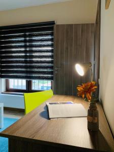 a desk with a lamp and a book on it at Brickyard Apartments Cluj in Cluj-Napoca
