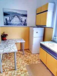 uma cozinha com uma mesa e um frigorífico em Apartma Vita em Rečica ob Savinji