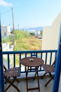 un tavolo in legno e 2 sedie sul balcone di Finikas Studios ad Adámas