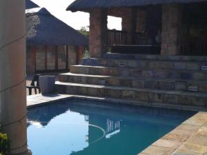 - une piscine dans une cour avec quelques marches dans l'établissement Stone Hounds Lodge, à Magaliesburg