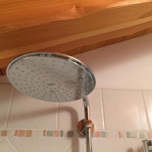 - un pommeau de douche au-dessus d'un lavabo dans l'établissement Chalet Delle Rose, à Santi di Daone
