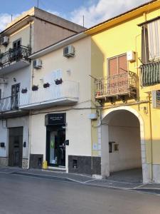 a yellow and white building with an archway and balcony at Flower house in Santa Maria La Carità