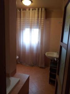 un bagno con lavandino e doccia con finestra di appartamento quadrifoglio a Desenzano del Garda