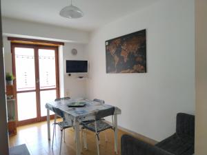 ein Esszimmer mit einem Tisch, Stühlen und einem TV in der Unterkunft Casa Parco Aranci in Formia