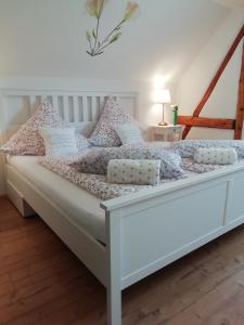 a white bed with pink and white pillows on it at Ferienhaus am Haselbach in Ebershausen