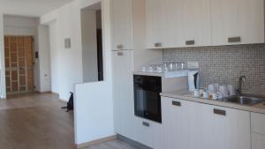 a white kitchen with a sink and a stove at Valdagri BnB in SantʼArcangelo