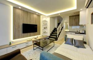 sala de estar con sofá y TV y escalera en Emerald Apartment, en Mostar