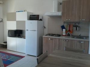 eine Küche mit einem weißen Kühlschrank und einer Spüle in der Unterkunft CASA MARTA SANDO in San Domenico