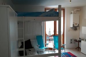 Litera con 2 sillas azules en una habitación en CASA MARTA SANDO, en San Domenico