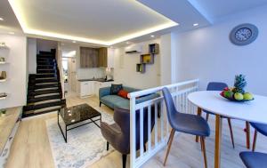 sala de estar con mesa y sillas y cocina en Emerald Apartment, en Mostar
