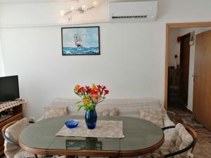 a living room with a table with a vase of flowers at Apartment Zarace in Zarače