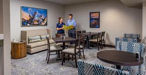 two men standing in a room with tables and chairs at Bridgewater Hotel, Trademark Collection by Wyndham in Fairbanks