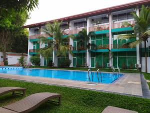 un hotel con piscina frente a un edificio en ACME Grand Hotel en Habarana