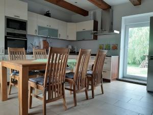 Ferienhaus Flotte Biene in Buggow في Rubkow: مطبخ مع طاولة طعام وكراسي خشبية