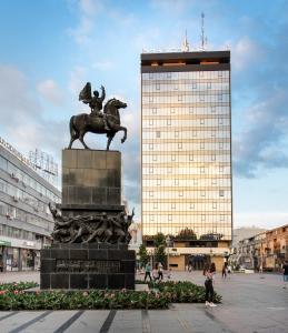 a statue of a man on a horse in front of a building at Ambasador Hotel in Niš